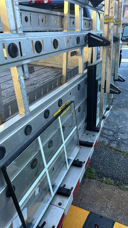 Professional window glass storage rack system with multiple aluminum frames and safety glass panels in organized sections