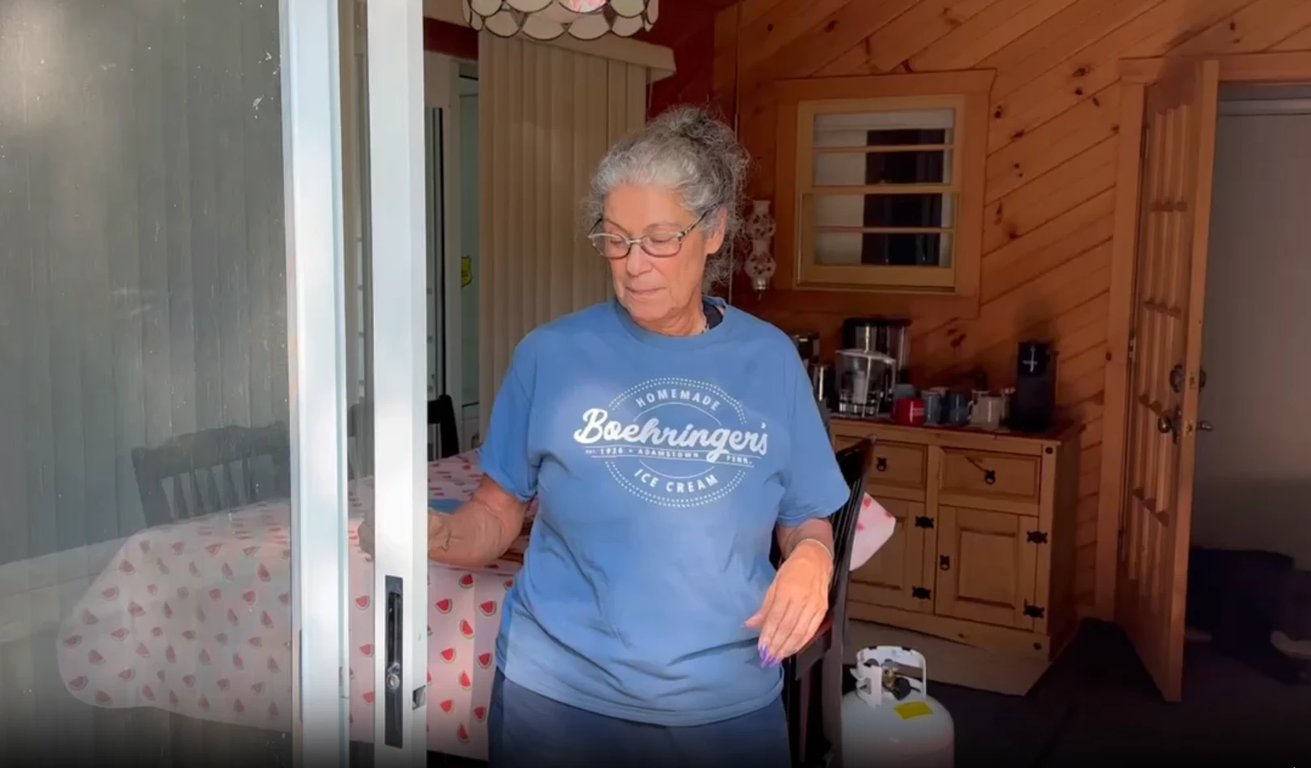 Home repair specialist inspecting sliding glass door in Charlotte home with wooden interior and kitchen background