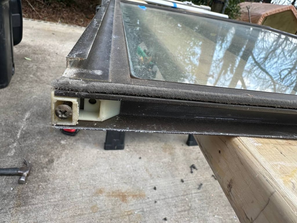 Detailed view of window frame assembly showing weatherstripping and mounting hardware requiring professional repair service