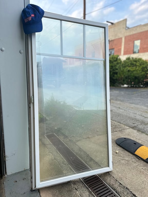 Commercial glass door frame replacement service in North Carolina, with WOW company branding and professional installation equipment