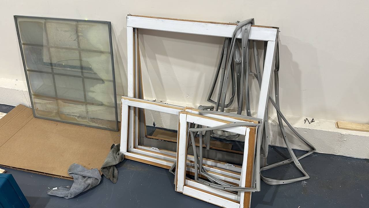 Disassembled window frames and glass units showing window repair and replacement components in North Carolina