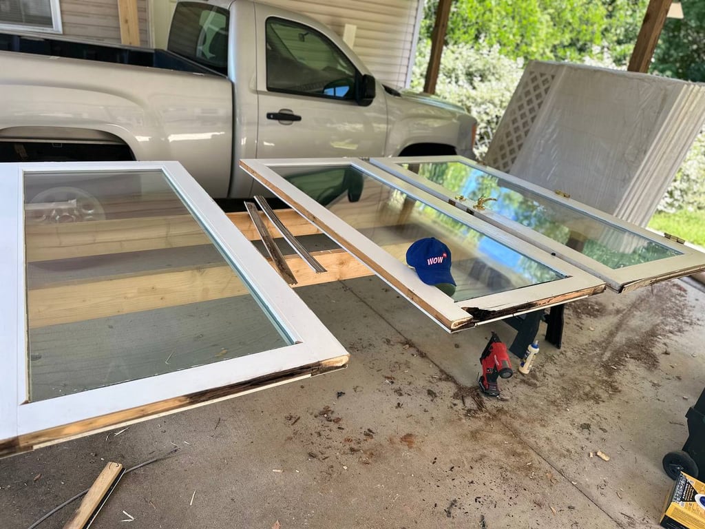 Window restoration in progress showing disassembled wooden window frames and glass panes with professional repair tools in North Carolina